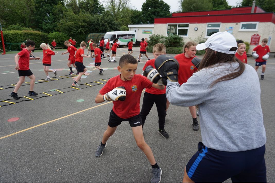 A coach working with children on pad drills during a Challenge session