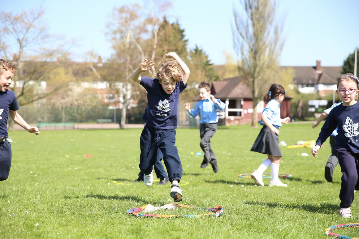 Children taking part in an agility game with hoops and ladders on the school field